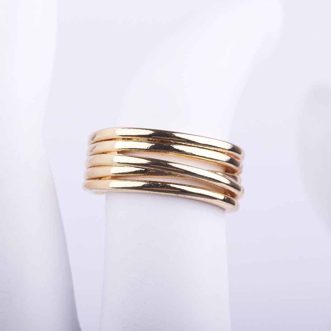 Anillo ancho dorado compuesto por varias bandas finas entrelazadas con acabado brillante sobre fondo blanco.