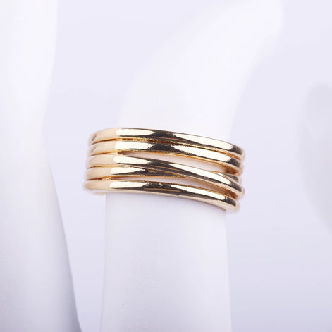 Anillo ancho dorado compuesto por varias bandas finas entrelazadas con acabado brillante sobre fondo blanco.