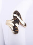 Anillo ancho dorado de diseño fluido y orgánico con acabado brillante tipo espejo sobre fondo blanco.