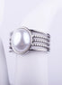 Anillo ancho plateado con una gran perla central y banda decorativa de cinco niveles lisos y de cuentas sobre fondo blanco.