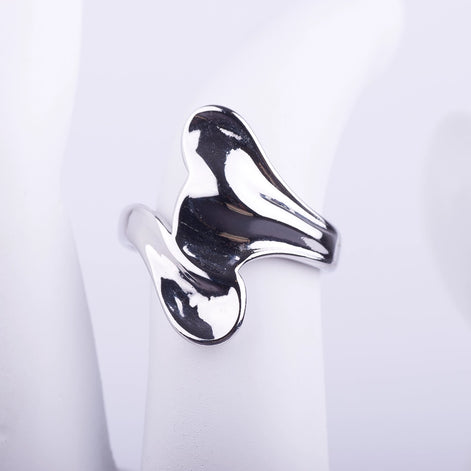 Anillo ancho plateado de forma irregular y fluida con acabado brillante tipo espejo sobre fondo blanco.