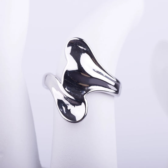 Anillo ancho plateado de forma irregular y fluida con acabado brillante tipo espejo sobre fondo blanco.
