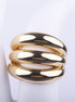 Anillo ancho dorado de tres bandas gruesas y abombadas con acabado brillante sobre fondo blanco.