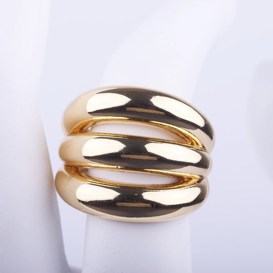 Anillo ancho dorado de tres bandas gruesas y abombadas con acabado brillante sobre fondo blanco.