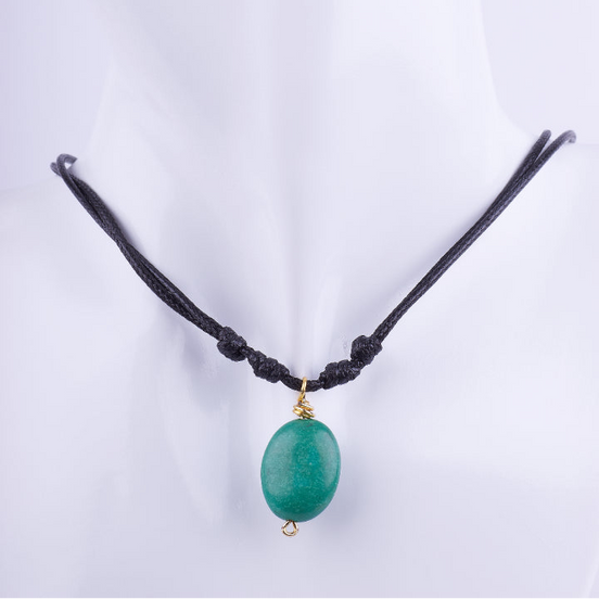 Collar estilo choker de cordón doble de macramé negro con un dije de piedra natural ovalada de color verde jade. La piedra está envuelta en alambre dorado, exhibido en un busto de maniquí blanco.