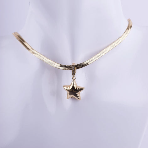 Collar de cadena plana tipo serpiente (herringbone) bañada en oro, con dije de estrella voluminosa y detalles de zirconia. Joyería de alta moda.
