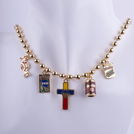 Collar gargantilla de cadena de bolas doradas con dijes esmaltados de iconos venezolanos: Harina P.A.N., Cruz con bandera, Pirulín y lata de Malta.