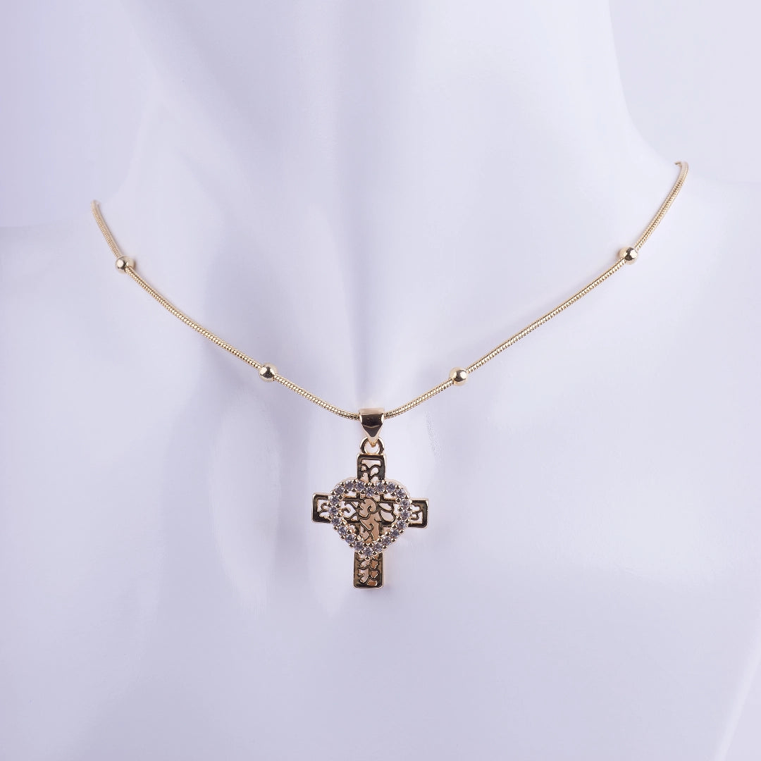 Collar con dije de cruz dorada de filigrana con corazón central de circonitas. Joyería religiosa elegante y fina