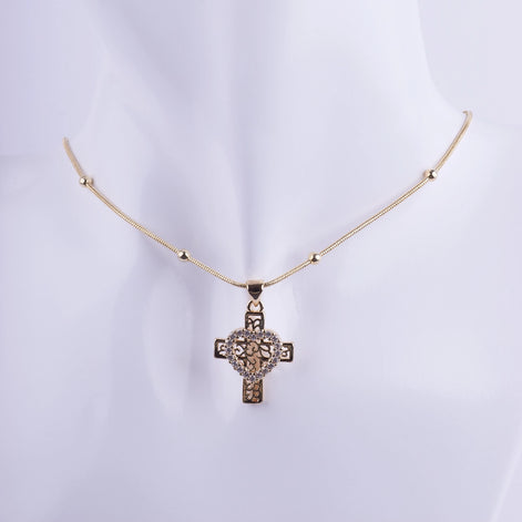 Collar con dije de cruz dorada de filigrana con corazón central de circonitas. Joyería religiosa elegante y fina