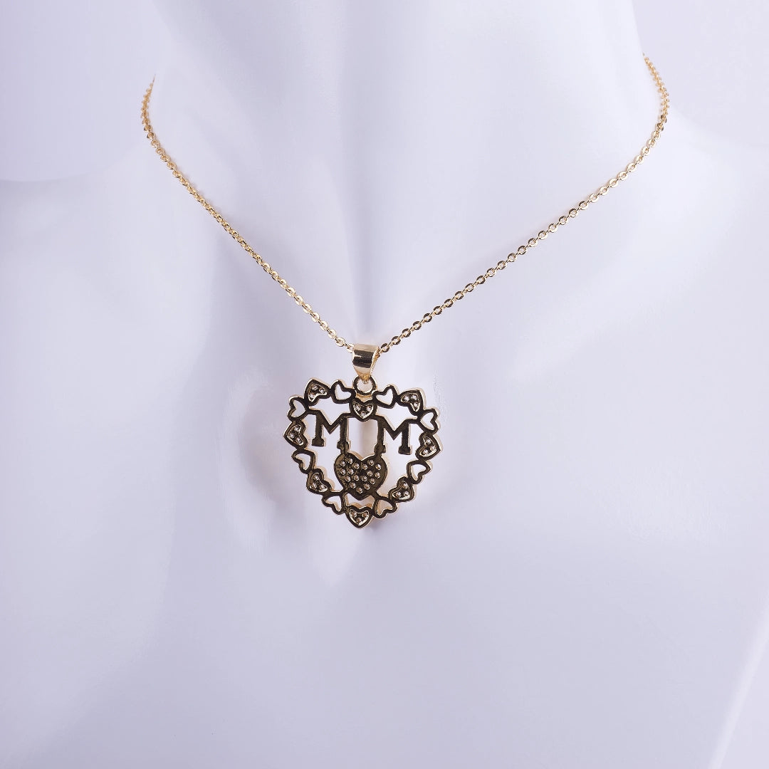 Collar con dije de corazón de filigrana bañado en oro, la palabra MAMÁ en el centro y micro zirconias. Regalo perfecto para el Día de la Madre.