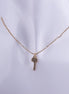Collar dorado con dije de palmera brillante y cadena de esferas pequeñas sobre busto blanco, joyería de estilo tropical y elegante.