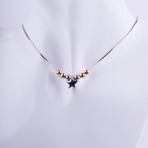 Collar minimalista con un dije de estrella plateada y cuentas en tonos oro, plata y oro rosa sobre una cadena de serpiente fina.