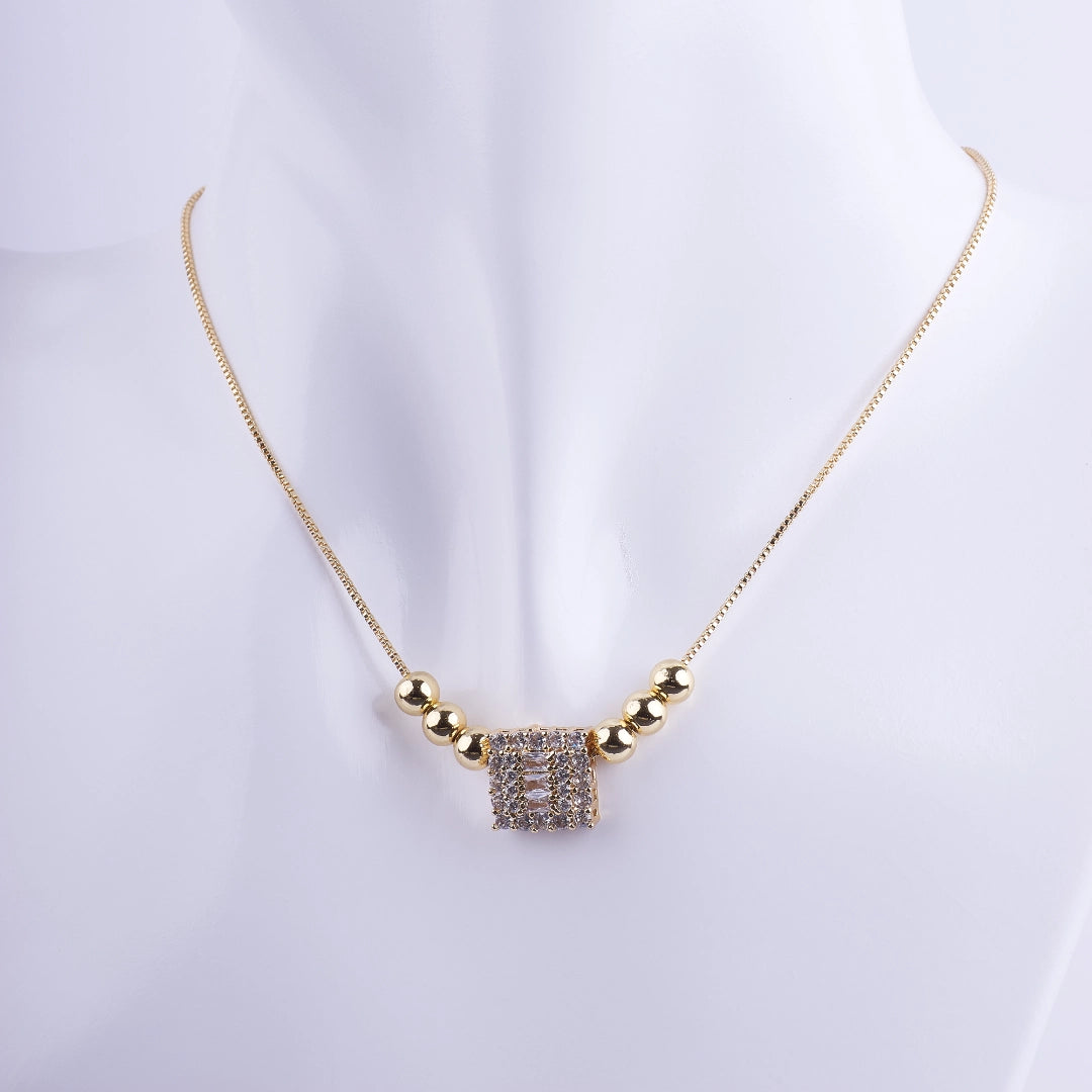 Collar bañado en oro con dije cuadrado de zirconias brillantes y esferas doradas sobre cadena veneciana fina