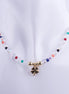 Collar gargantilla de hilo transparente con dije de trébol de cuatro hojas bañado en oro, rodeado de cuentas de cristal facetado transparente y multicolor (arcoíris).