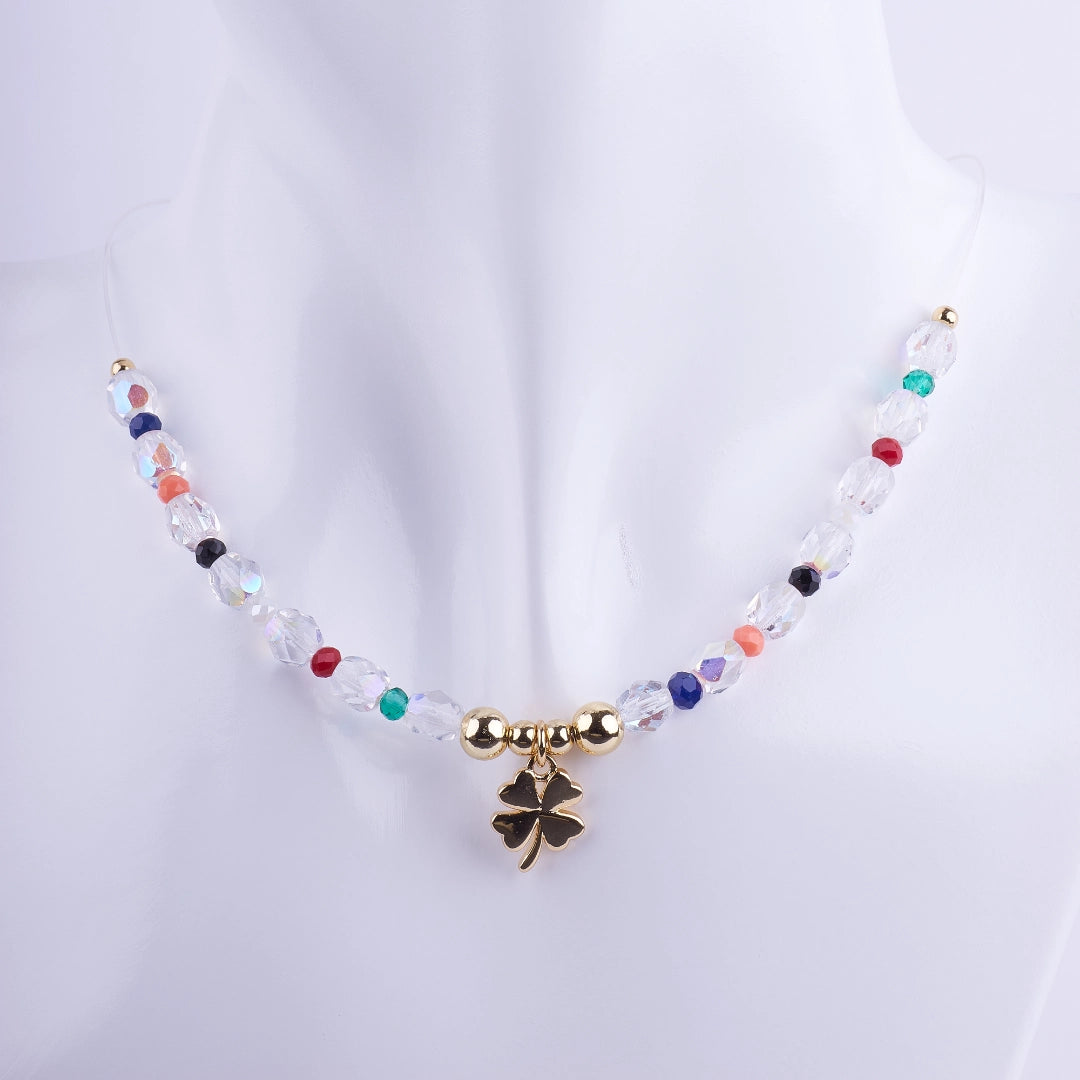 Collar gargantilla de hilo transparente con dije de trébol de cuatro hojas bañado en oro, rodeado de cuentas de cristal facetado transparente y multicolor (arcoíris).