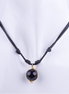 Collar estilo choker de cordón doble de macramé negro con un dije de esfera de piedra negra (Obsidiana u Ónix) envuelto en alambre dorado. El cordón es ajustable con nudos, exhibido en un busto de maniquí blanco.