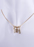 Collar de odontología bañado en oro con tres dijes: una muela con zirconias, un cepillo de dientes y una pasta dental sobre cadena de serpiente.