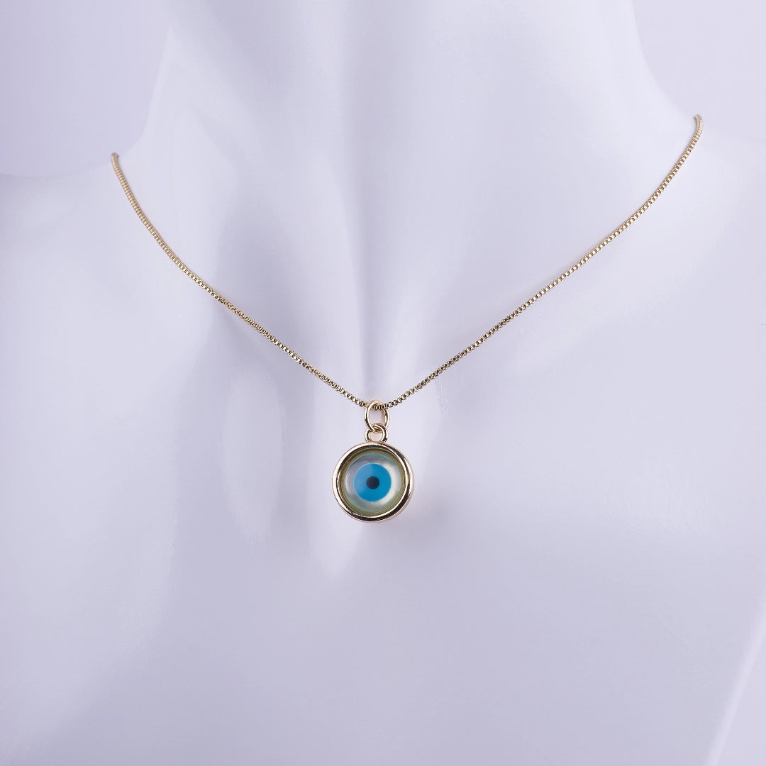 Collar dorado con dije circular de Ojo Turco (Nazar) en azul y blanco sobre una cadena veneciana fina. Amuleto de protección contra el mal de ojo.