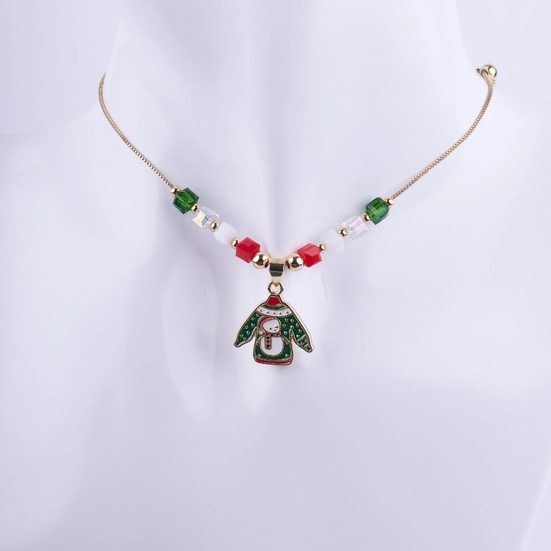 Collar navideño "Ugly Sweater" con dije esmaltado de suéter y muñeco de nieve, adornado con cuentas cúbicas de cristal rojo, verde y blanco, con cadena dorada.