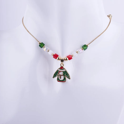 Collar navideño "Ugly Sweater" con dije esmaltado de suéter y muñeco de nieve, adornado con cuentas cúbicas de cristal rojo, verde y blanco, con cadena dorada.