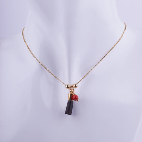 Collar Cadena Fina Dorada con Colgante de Turmalina Negra Bruta y Coral Rojo en maniquí blanco. Joyería de protección minimalista.