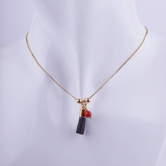Collar Cadena Fina Dorada con Colgante de Turmalina Negra Bruta y Coral Rojo en maniquí blanco. Joyería de protección minimalista.