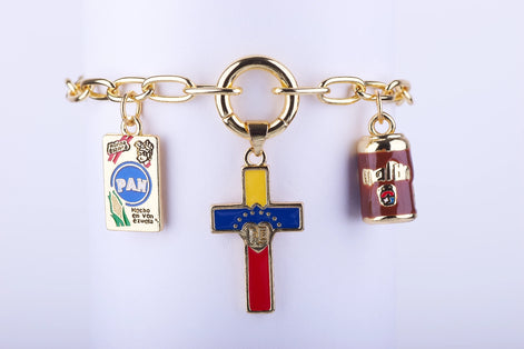 Pulsera de cadena color en oro con dije central de cruz esmaltada con la bandera de Venezuela, dije de Harina P.A.N. y dije de lata Maltín Polar