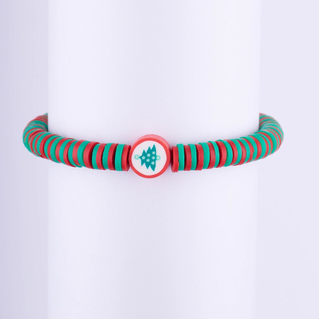 Pulsera navideña minimalista con cuentas de disco (Heishi) rojas y verdes, y una cuenta central con el diseño de un Árbol de Navidad.