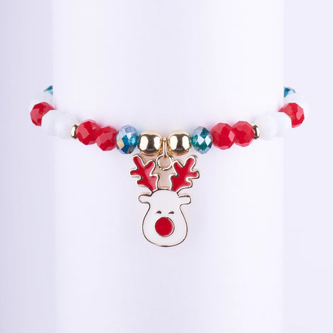 Pulsera elástica de perlas blancas y cuentas rojas, con separadores dorados con pedrería y un dije de reno esmaltado blanco y rojo.
