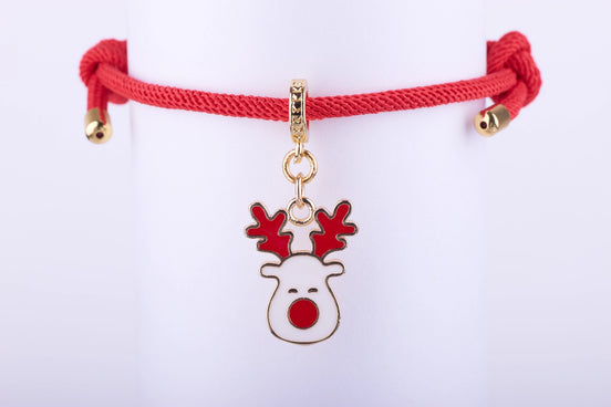 Pulsera de cordón rojo ajustable con dije de reno navideño esmaltado en blanco y rojo, con astas rojas y nariz roja, y detalles dorados.