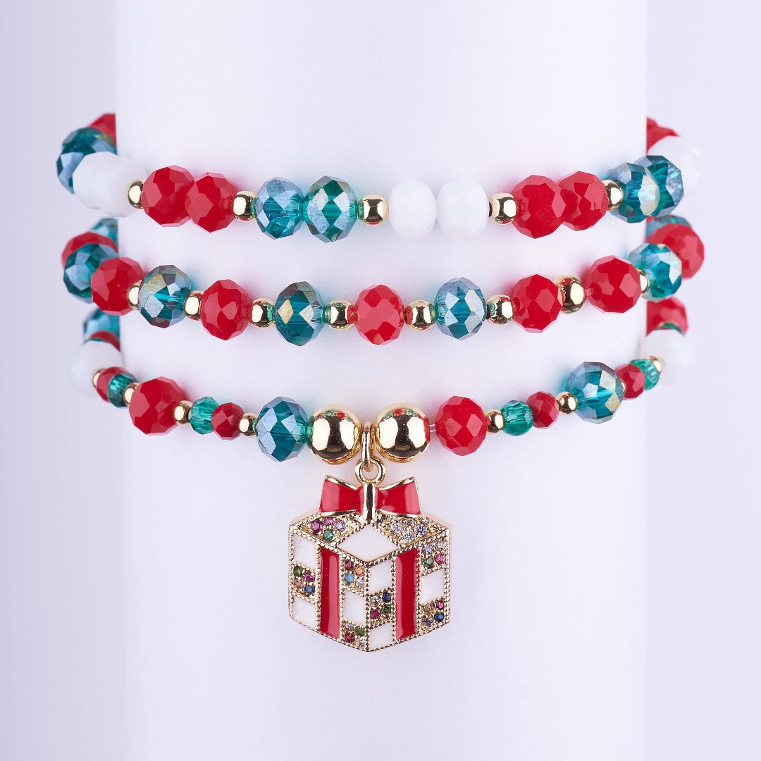 Set de 3 pulseras navideñas de cuentas de cristal facetado rojas, verdes y blancas con separadores dorados y un dije de regalo esmaltado y con brillantes.